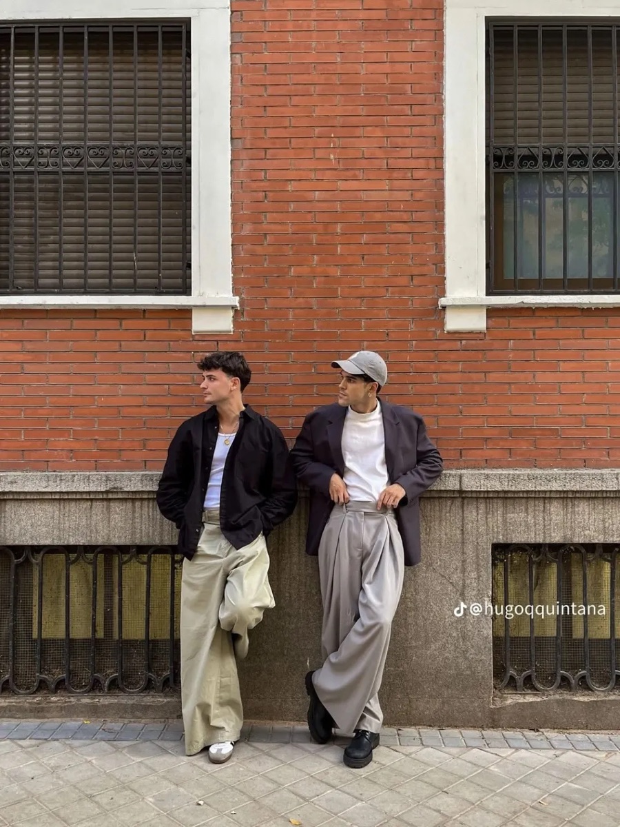 Two people in overshirts and pleated trousers